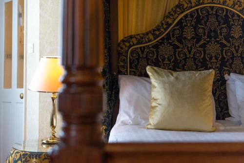 a bed with a pillow and a lamp on a table at Best Western Red Lion Hotel in Salisbury