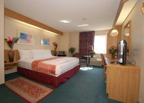 a hotel room with a bed and a television at Rodeway Inn Willington North in Willington Hill