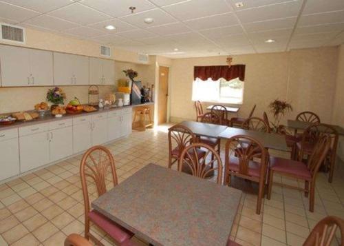 a kitchen with a table and chairs and a table and a counter at Rodeway Inn Willington North in Willington Hill