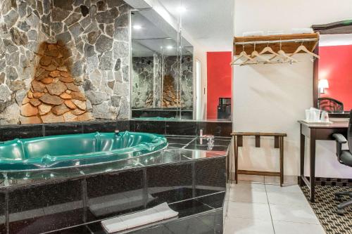 a bathroom with a tub and a stone wall at Econo Lodge in West Haven