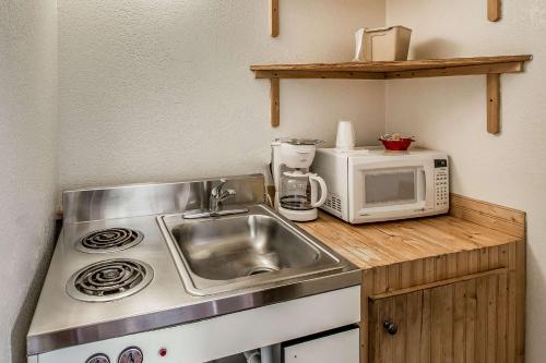 a small kitchen with a sink and a microwave at Rodeway Inn Rifle in Rifle