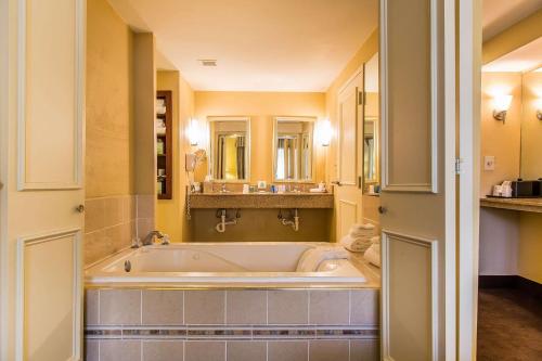 a large bathroom with a tub and a sink at Clarion Hotel & Suites Hamden - New Haven in Hamden
