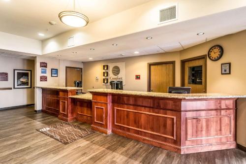 a lobby with a bar with a clock on the wall at Comfort Inn & Suites Rifle in Rifle