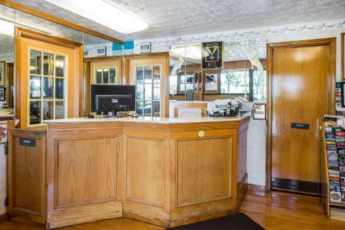 a kitchen with wooden cabinets and a counter top at Rodeway Inn & Suites Branford - Guilford in Branford