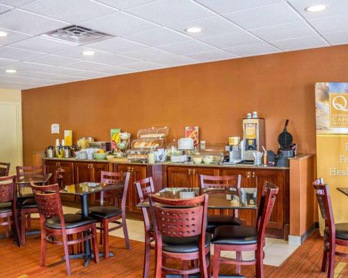 a restaurant with tables and chairs and a counter at Quality Inn Waterbury in Waterbury