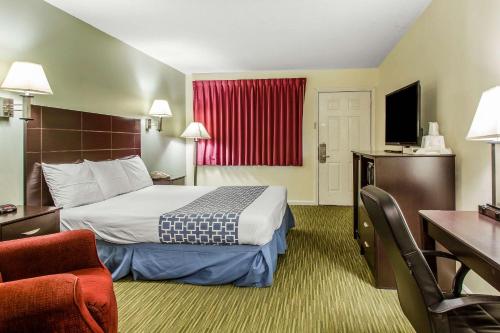 a hotel room with a bed and a television at Rodeway Inn in Groton