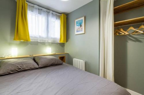 um quarto com uma cama e uma janela com cortinas amarelas em Calme appart rénové Jardin des Plantes Busca em Toulouse