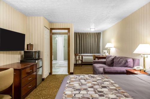 a hotel room with a couch and a living room at Rodeway Inn & Suites Branford - Guilford in Branford
