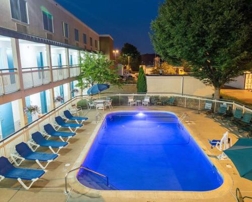 a swimming pool with lounge chairs and a building at Quality Inn Newark - Wilmington in Newark
