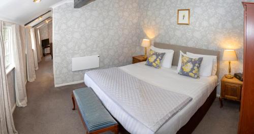 a bedroom with a large white bed with blue pillows at Best Western Red Lion Hotel in Salisbury