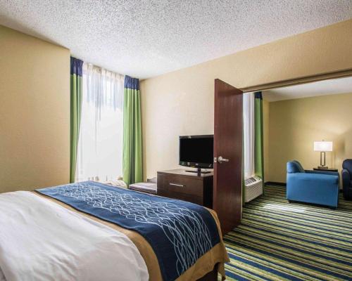 a hotel room with a bed and a television at Comfort Inn & Suites Lantana - West Palm Beach South in Lantana