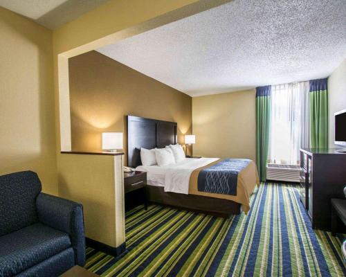 a hotel room with a bed and a chair at Comfort Inn & Suites Lantana - West Palm Beach South in Lantana