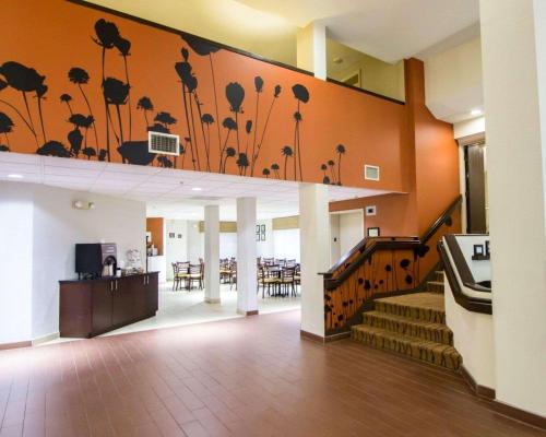 a lobby with stairs and a mural of flowers on the wall at Sleep Inn Ormond Beach - Daytona in Ormond Beach