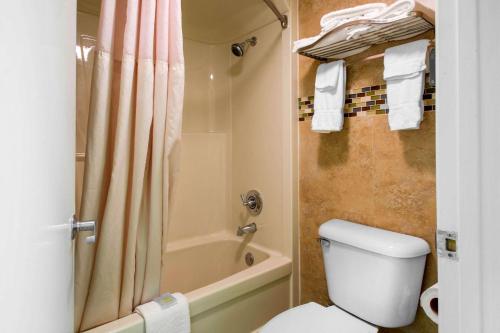 y baño con ducha, aseo y bañera. en Quality Inn Clermont West Kissimmee, en Kissimmee