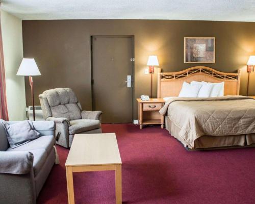 Habitación de hotel con cama, sofá y silla en Quality Inn & Suites St Augustine Beach Area, en St. Augustine Beach