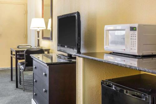 a hotel room with a microwave and a computer on a counter at Mi Casa Hotel in Orlando