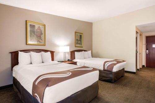 a hotel room with two beds and two lamps at Quality Inn & Suites Tarpon Springs South in Tarpon Springs