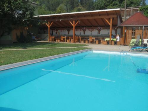 a large swimming pool with a picnic table and chairs at Gasthof Maly in Mauthausen