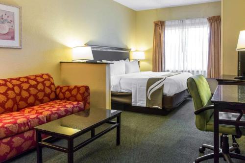 オーランドにあるMi Casa Hotelのベッドとソファ付きのホテルルーム