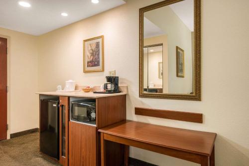 a hotel room with a microwave and a mirror at Quality Inn & Suites Tarpon Springs South in Tarpon Springs