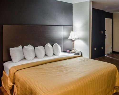 Quality Inn At Eglin AFB في نايسفيل: غرفة فندق بسرير كبير ومخدات بيضاء