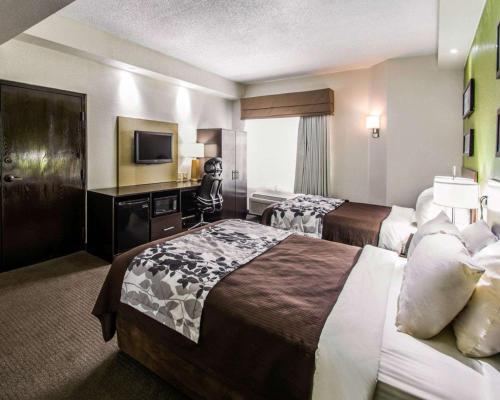 a hotel room with two beds and a television at Sleep Inn Fort Pierce I-95 in Fort Pierce