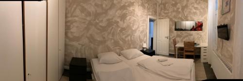 um quarto com uma cama com lençóis brancos e uma parede em AB Apartment Objekt 54 em Esslingen