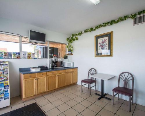 a kitchen with a counter and a table and chairs at Rodeway Inn Fort Pierce I-95 in Fort Pierce