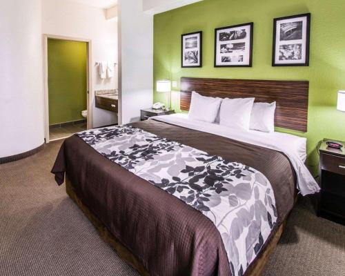 a large bed in a hotel room with green walls at Sleep Inn Fort Pierce I-95 in Fort Pierce