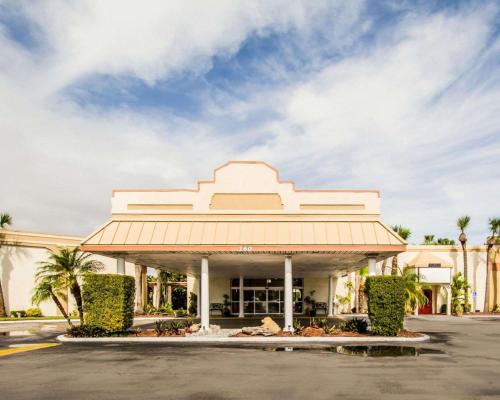 a large white building with palm trees in front of it at ISLAND HOTEL of Space Coast in Merritt Island