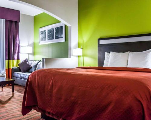 a hotel room with a bed and a couch at Quality Suites Fort Myers I-75 in Fort Myers
