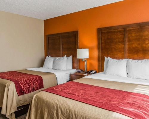 two beds in a hotel room with orange walls at Comfort Inn & Suites Lakeland North I-4 in Lakeland