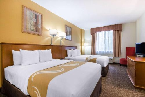 um quarto de hotel com duas camas e uma televisão em Quality Inn & Suites Near the Theme Parks em Orlando