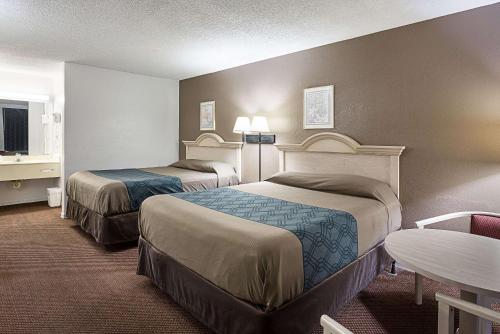 a hotel room with two beds and a table at Rodeway Inn Lake City I-75 in Lake City