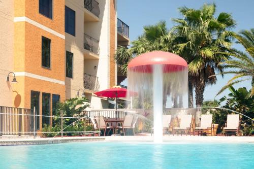 a fountain in a swimming pool next to a building at Castillo Real Resort Hotel in Saint Augustine Beach