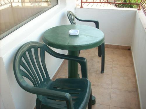 einen grünen Tisch und zwei Stühle auf dem Balkon in der Unterkunft Guest House Pepina in Sozopol
