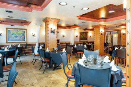 un comedor con mesas y sillas azules en Castillo Real Resort Hotel, en St. Augustine Beach