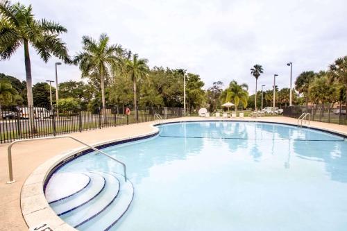 una gran piscina en un parque con palmeras en Sleep Inn Miami Airport, en Miami