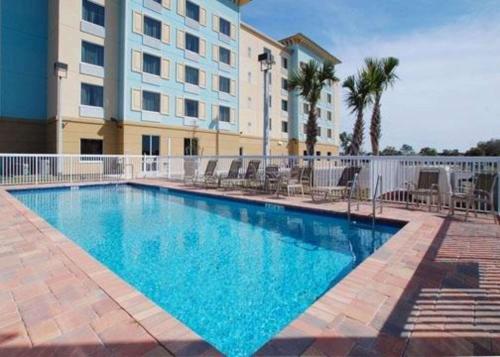 a large swimming pool in front of a building at Comfort Suites Palm Bay - Melbourne in Palm Bay