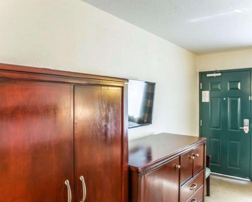 um quarto com um armário de madeira e uma porta verde em Econo Lodge em Lloyd