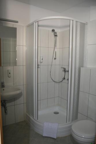 a bathroom with a shower with a toilet and a sink at Panoráma Panzió in Matrafured