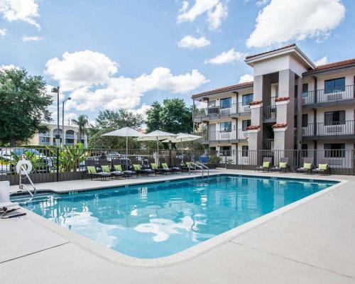 a pool with chairs and umbrellas at a hotel at Quality Inn & Suites By the Parks in Orlando