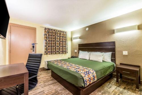 Habitación pequeña con cama y escritorio en Rodeway Inn Fairgrounds-Casino en Tampa