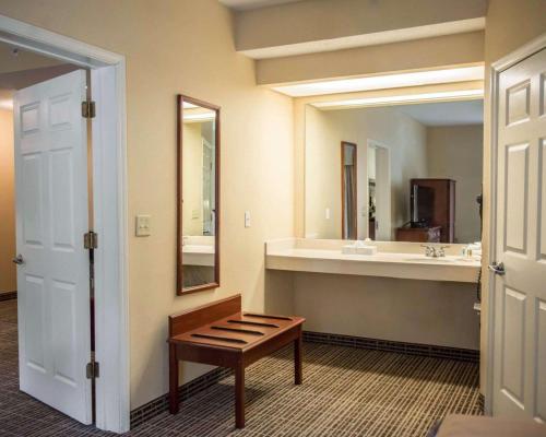 a bathroom with a sink and a bench and a mirror at Quality Inn Lake City in Lake City
