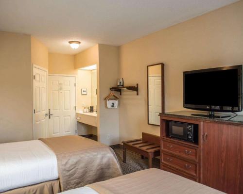 a hotel room with two beds and a flat screen tv at Quality Inn Lake City in Lake City