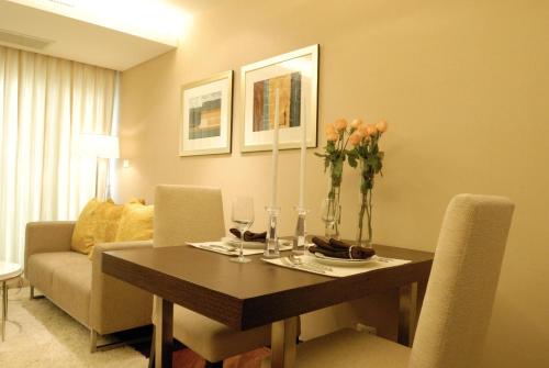 a dining room with a table and a couch at The Narathiwas Hotel & Residence Sathorn Bangkok in Bangkok