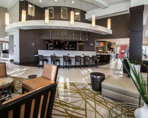 a lobby with a bar and some chairs and tables at Comfort Suites Miami Airport North in Miami