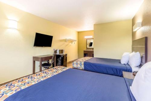 a hotel room with two beds and a television at Rodeway Inn Fairgrounds-Casino in Tampa