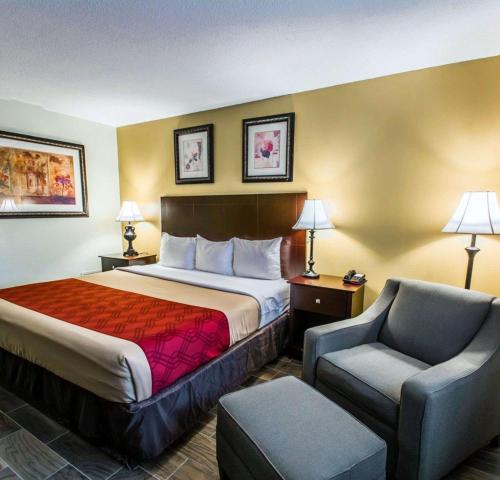 a hotel room with a bed and a chair at Econo Lodge Cocoa Beach - near the Port in Cocoa Beach