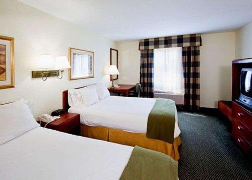 a hotel room with two beds and a flat screen tv at Econo Lodge in Wesley Chapel